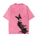 A pink vintage t-shirt with a graphic backprint featuring a butterfly and plant design.