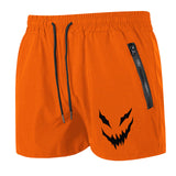 Orange shorts with a black jack-o'-lantern face design on a white background
